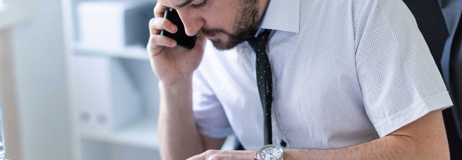 Man looking at a notebook while talking on the phone