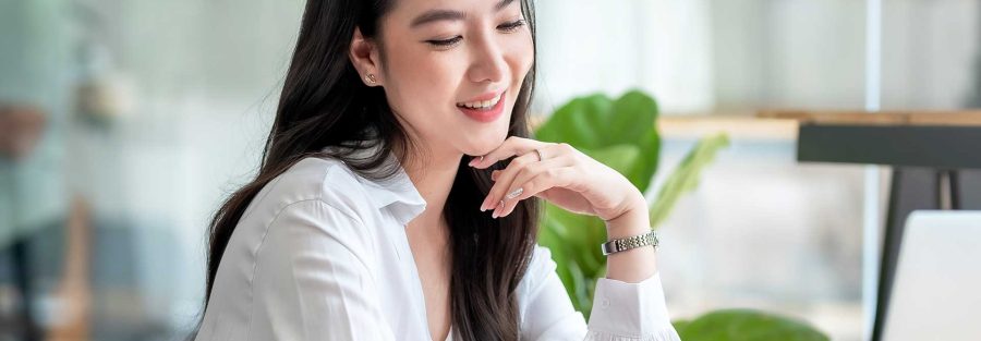 Woman smiling while looking at a laptop screen