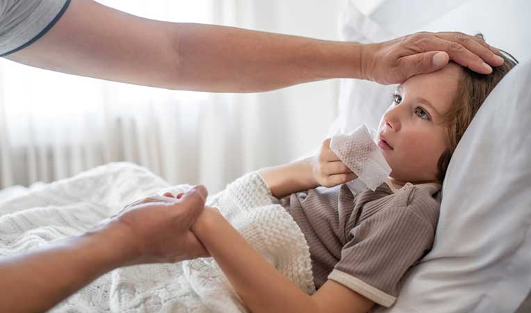 Sick child lying on a bed.