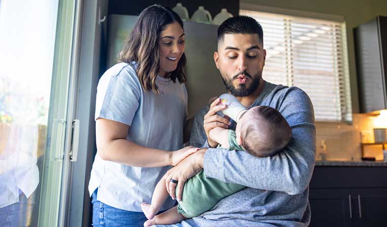 Shot of a new mom and dad feeding their baby with a bottle